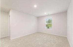 carpeted empty room featuring baseboards and recessed lighting