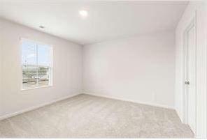 carpeted empty room featuring baseboards