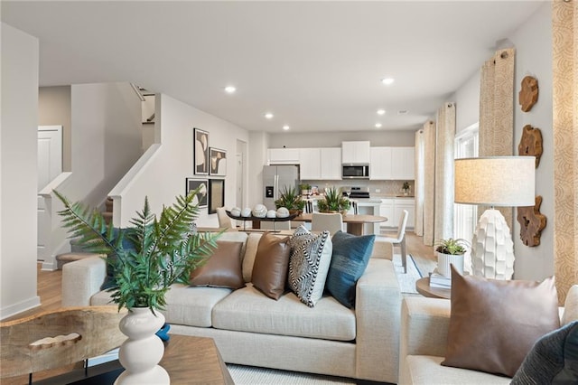 kitchen with a center island with sink, a fireplace, dishwasher, and wood finished floors