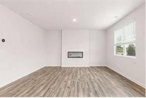 unfurnished living room with a fireplace and wood finished floors