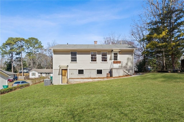 back of property featuring central AC unit and a yard