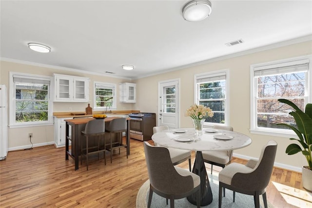 dining room featuring ornamental molding and light wood-type flooring