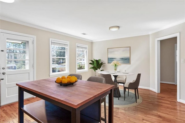 dining room featuring light hardwood / wood-style flooring and ornamental molding