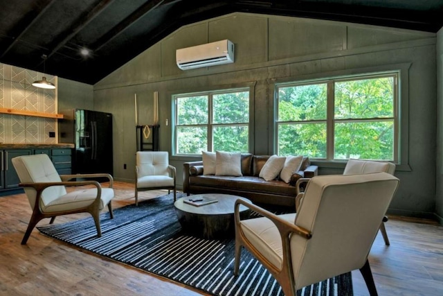 living room with vaulted ceiling, plenty of natural light, a wall mounted air conditioner, and wood finished floors