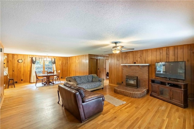 5670 Lanny Dr, Powder Springs, GA 30127 - living area featuring a textured ceiling, a ceiling fan, light wood-style flooring, wooden walls, and a fireplace