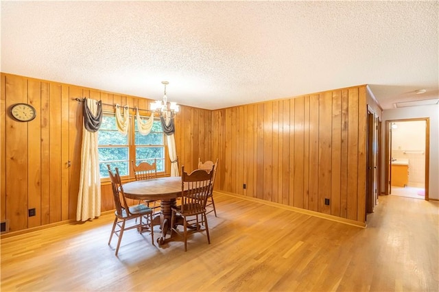 5670 Lanny Dr, Powder Springs, GA 30127 - dining area featuring wood finished floors, a textured ceiling, wood walls, and a chandelier