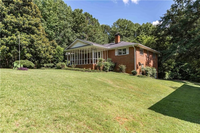 5670 Lanny Dr, Powder Springs, GA 30127 - rear view of property featuring a chimney, brick siding, a lawn, and a sunroom
