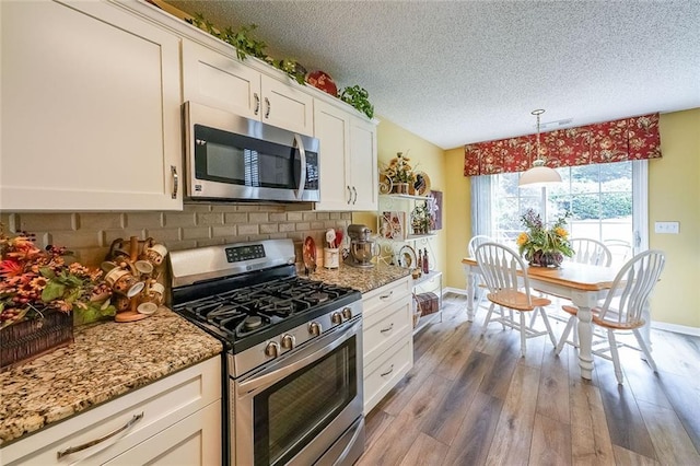 626 Dahoma Trl, Woodstock, GA 30188 - kitchen with appliances with stainless steel finishes, a textured ceiling, wood finished floors, backsplash, and baseboards