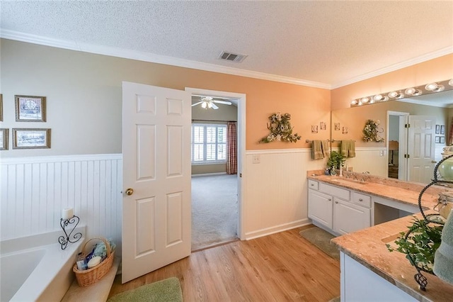 626 Dahoma Trl, Woodstock, GA 30188 - full bath featuring a wainscoted wall, wood finished floors, a textured ceiling, a garden tub, and vanity