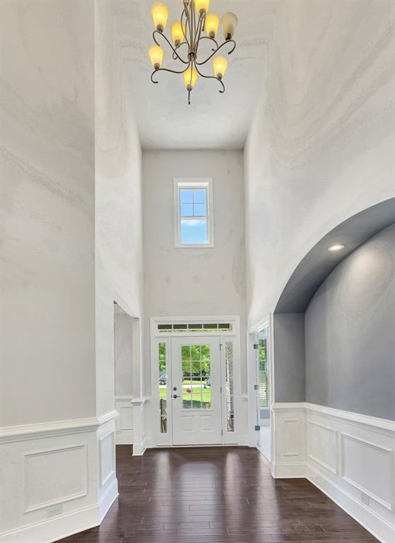 1231 Fawndale Dr NW, Kennesaw, GA 30152 - foyer entrance with a chandelier, a decorative wall, wood finished floors, a high ceiling, and a wainscoted wall