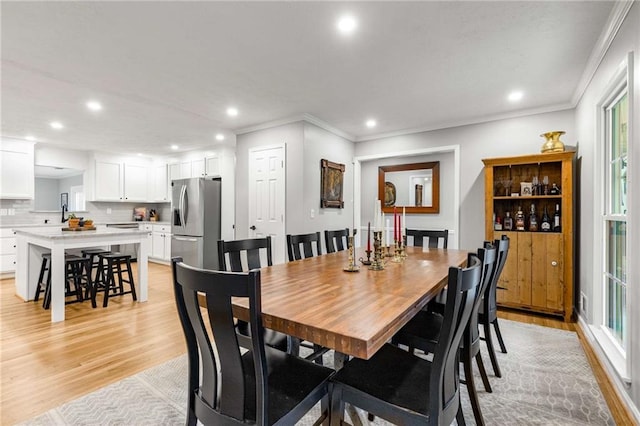 dining room featuring ornamental molding and light hardwood / wood-style flooring