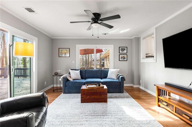 living room featuring crown molding, ceiling fan, and light wood-type flooring