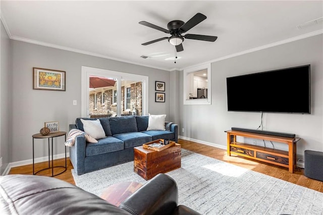 living room featuring crown molding, ceiling fan, and light hardwood / wood-style floors