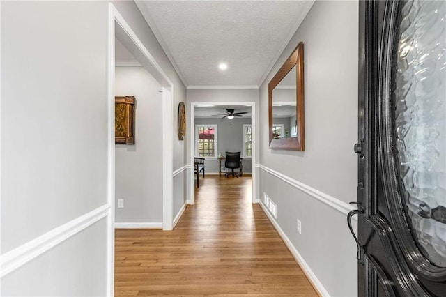 corridor featuring a textured ceiling and light wood-type flooring