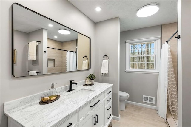 bathroom with vanity, hardwood / wood-style flooring, a shower with curtain, and toilet