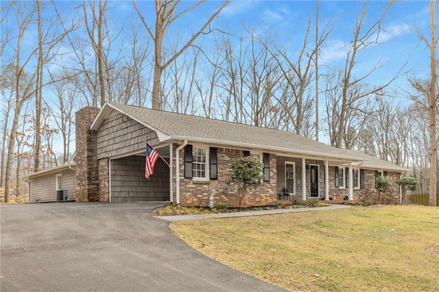 ranch-style house featuring a porch, a garage, central AC unit, and a front lawn