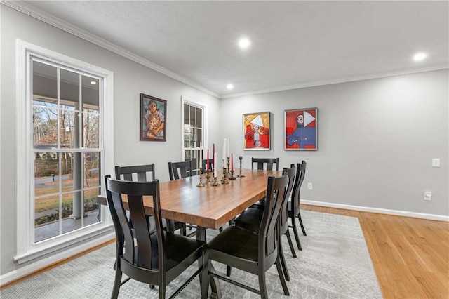 dining room featuring crown molding and light hardwood / wood-style flooring