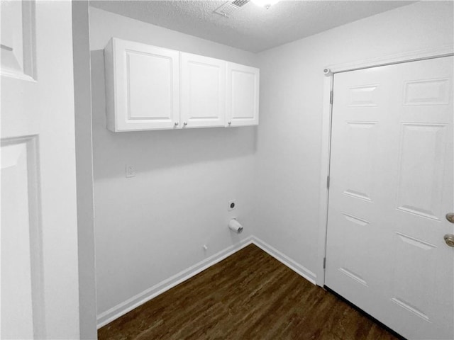 washroom with dark hardwood / wood-style flooring, electric dryer hookup, a textured ceiling, and cabinets