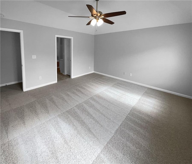 unfurnished bedroom featuring ceiling fan, a closet, and dark carpet