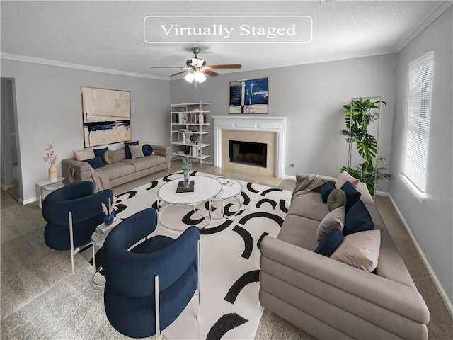 living room featuring a fireplace, a textured ceiling, ceiling fan, and crown molding