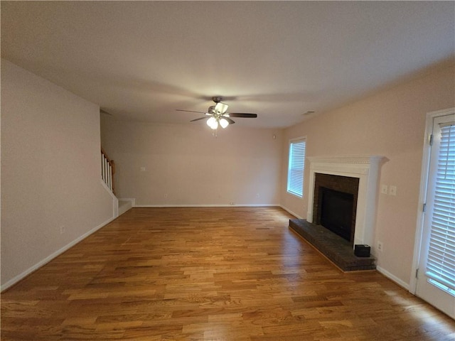 unfurnished living room with hardwood / wood-style floors, a fireplace, and ceiling fan