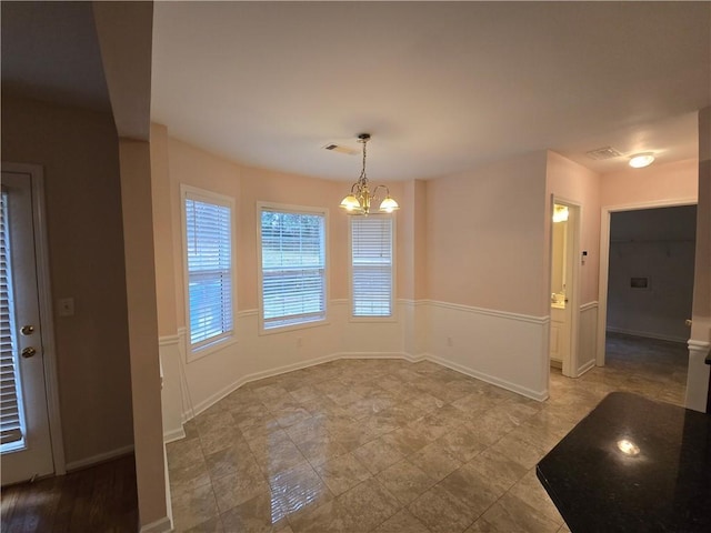 unfurnished dining area featuring an inviting chandelier