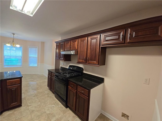 kitchen with dark brown cabinetry, a chandelier, pendant lighting, dark stone counters, and black gas range