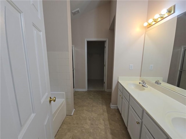 bathroom featuring vanity, tile patterned floors, and a bathtub