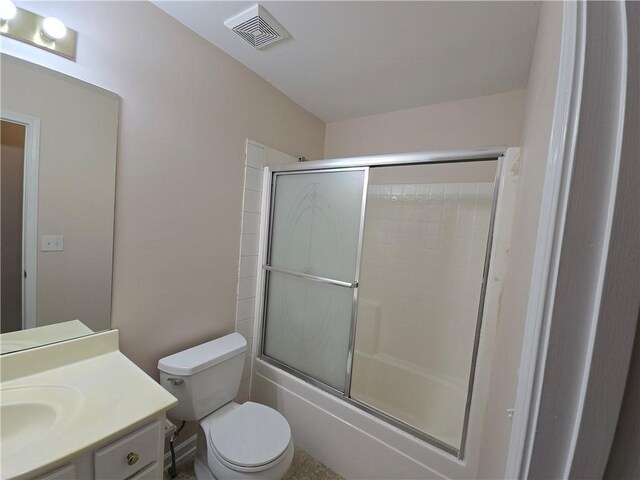 full bathroom featuring vanity, bath / shower combo with glass door, and toilet