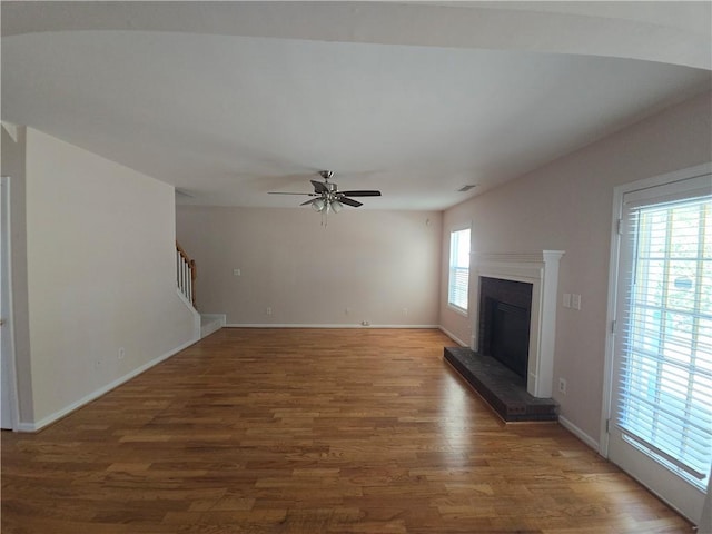 unfurnished living room with dark hardwood / wood-style floors and ceiling fan