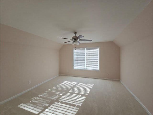 additional living space featuring vaulted ceiling, light colored carpet, and ceiling fan