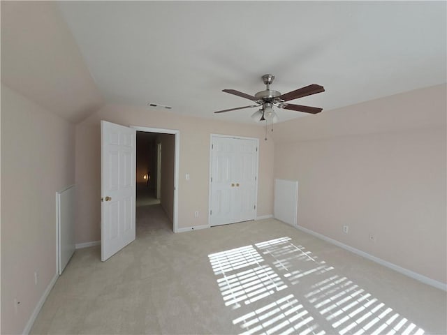 unfurnished bedroom featuring light carpet, ceiling fan, and a closet