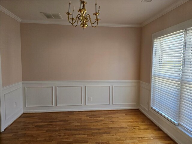 unfurnished room featuring ornamental molding, light hardwood / wood-style floors, and a chandelier