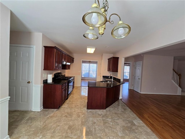 kitchen featuring black range with gas cooktop, a chandelier, sink, and light wood-type flooring