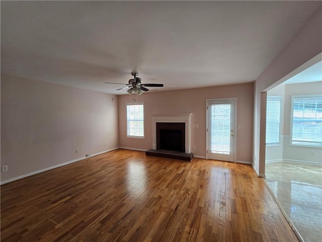 unfurnished living room with wood-type flooring and ceiling fan