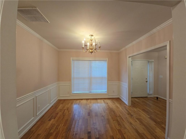 unfurnished dining area with a notable chandelier, crown molding, and wood-type flooring