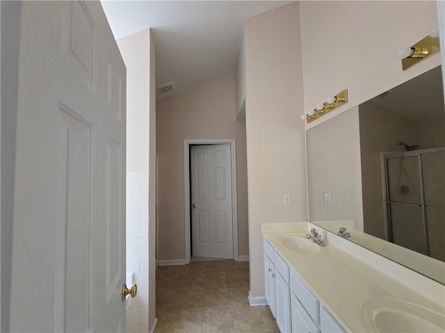 bathroom with walk in shower, lofted ceiling, vanity, and tile patterned floors