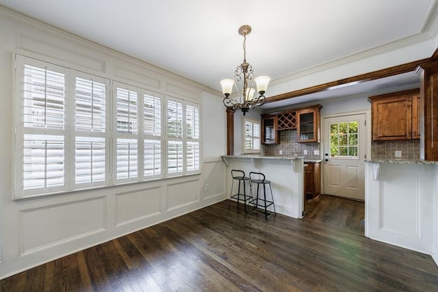 2668 Jefferson Ter, East Point, GA 30344 - kitchen featuring a chandelier, a kitchen bar, a decorative wall, dark wood-style floors, and a peninsula
