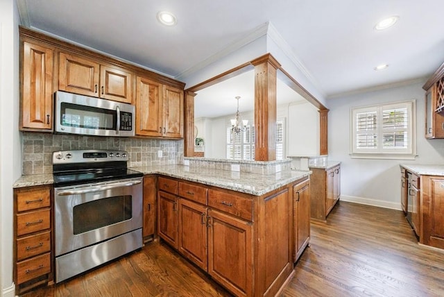 2668 Jefferson Ter, East Point, GA 30344 - kitchen with stainless steel appliances, brown cabinets, ornamental molding, a chandelier, and baseboards