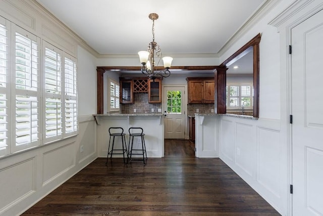 2668 Jefferson Ter, East Point, GA 30344 - kitchen with a chandelier, a peninsula, a decorative wall, decorative backsplash, and a kitchen bar