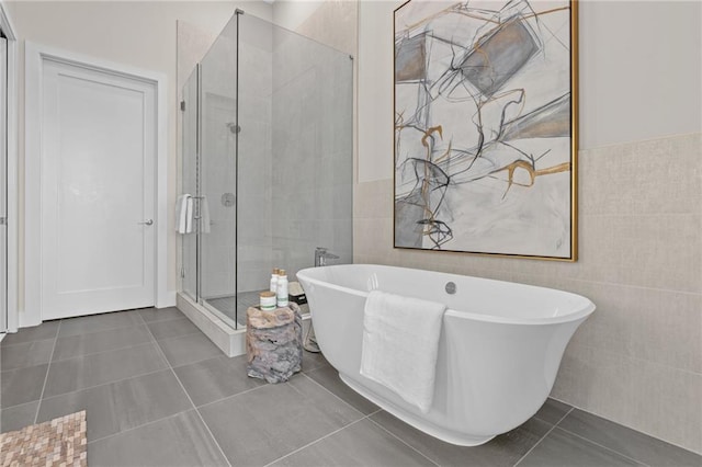 bathroom featuring tile patterned flooring, shower with separate bathtub, and tile walls