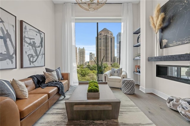 living room featuring built in features, hardwood / wood-style floors, and a notable chandelier