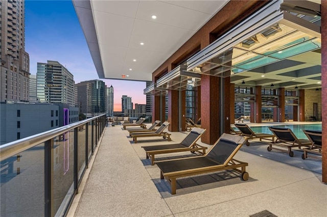 patio terrace at dusk featuring a balcony