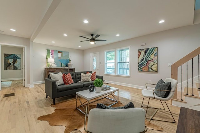 living room with recessed lighting, stairway, and light wood finished floors