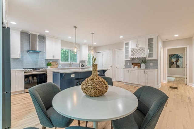 dining room featuring light wood-type flooring, visible vents, baseboards, and recessed lighting