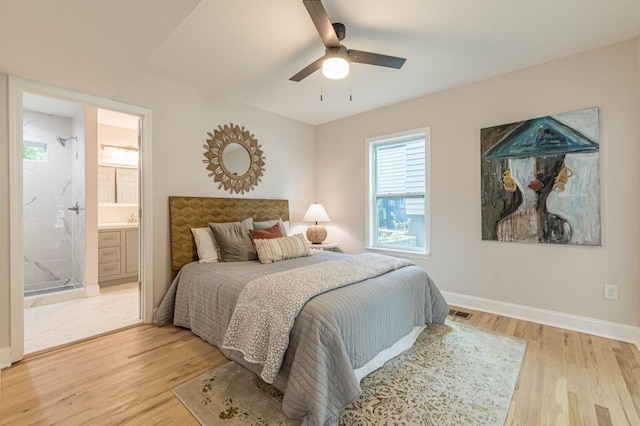 bedroom with light wood finished floors, visible vents, baseboards, a ceiling fan, and connected bathroom