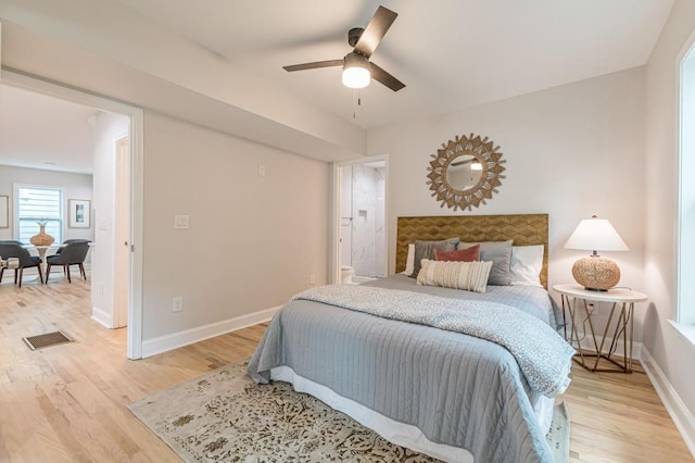 bedroom featuring baseboards, a ceiling fan, visible vents, and light wood-style floors