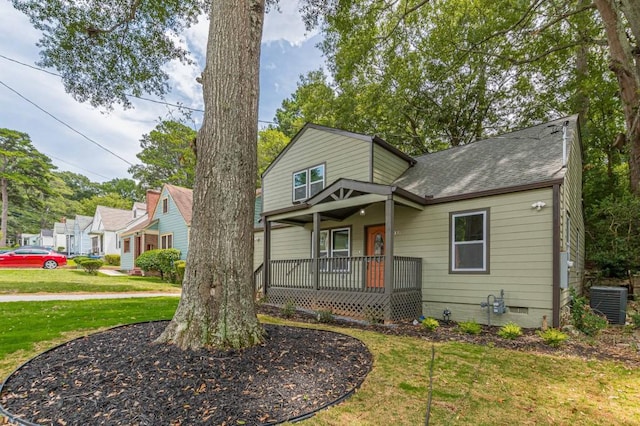 view of front of property with covered porch, a shingled roof, crawl space, and a front yard