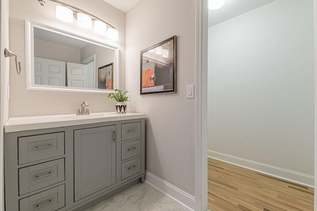 bathroom featuring marble finish floor, vanity, and baseboards