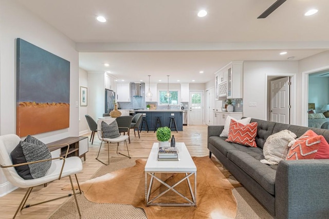 living area featuring a ceiling fan, recessed lighting, and light wood-style flooring